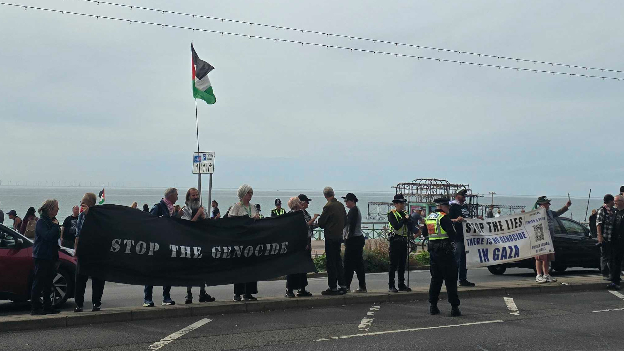Protesters and counter-protesters stand outside the Green Party conference on Saturday. (Imran Mulla/MEE)